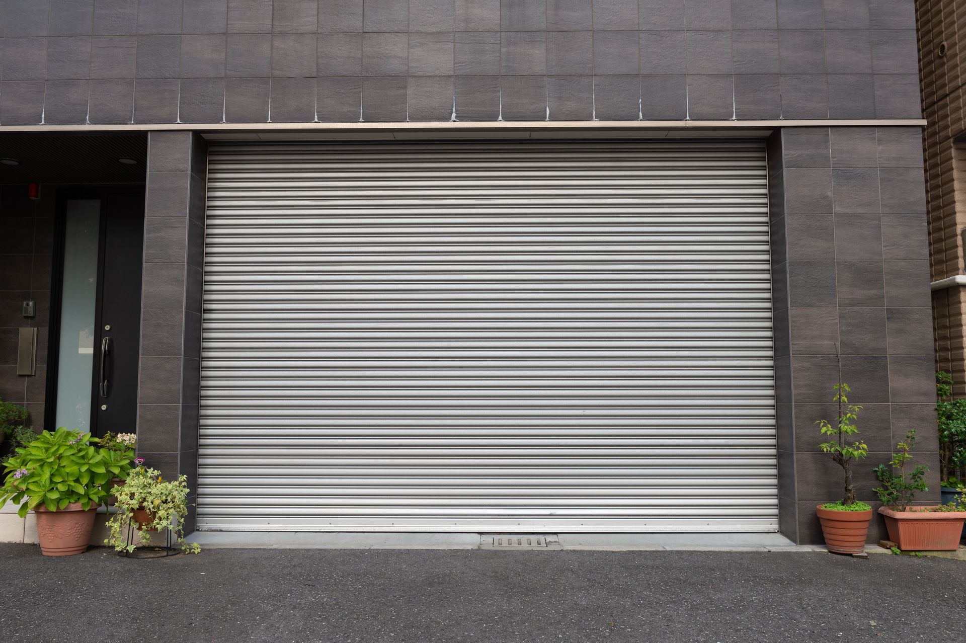 An automatic metal roller door used in a factory, storage, garage, or industrial warehouse entrance.