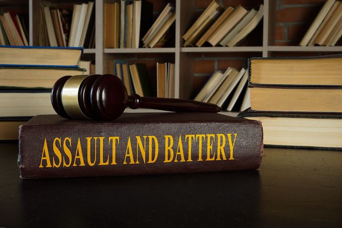 Gavel on a book titled “Assault and Battery” with law books in the background Gavel on a book titled “Assault and Battery” with law books in the background