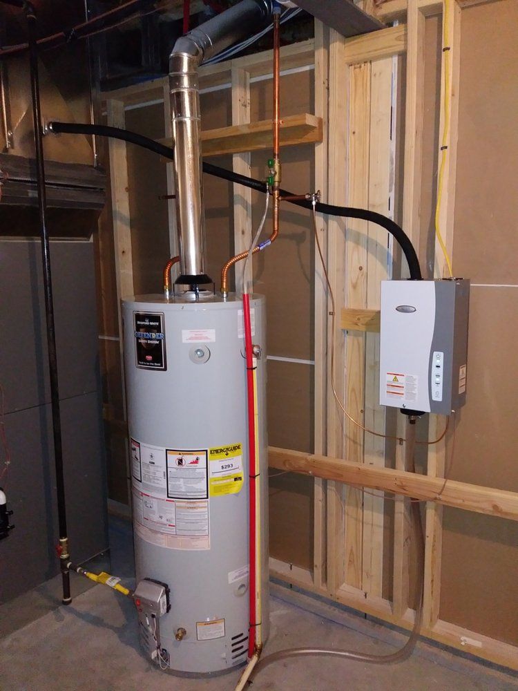 Water heater and tankless water heater installation in a basement. Plumbing and vent pipe visible.