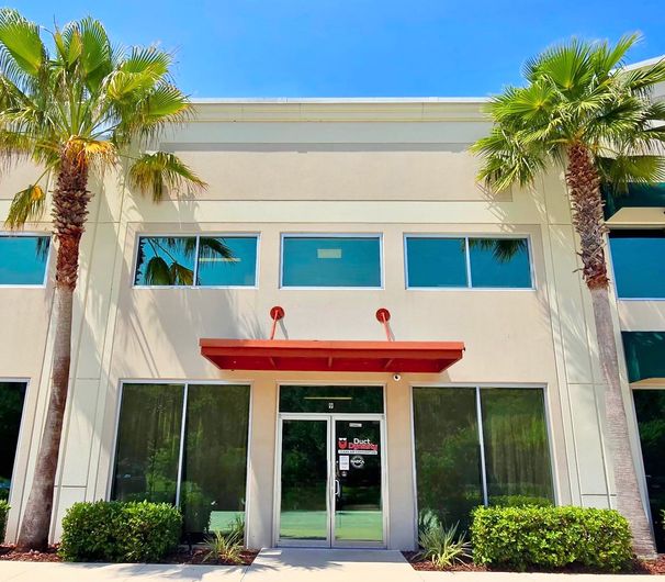 Duct Dynasty Office, White and orange building with Duct Dynasty logo on window door