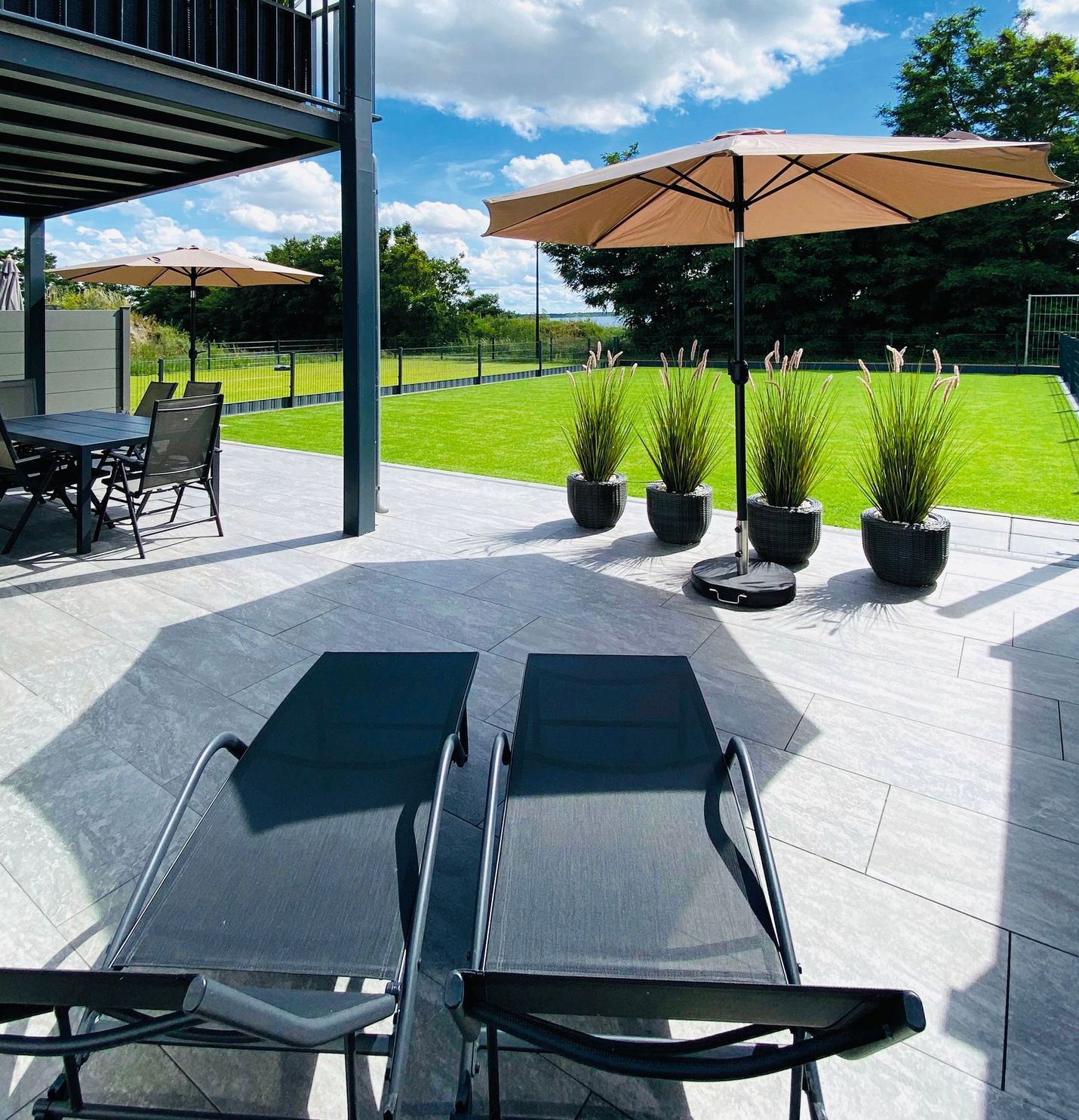 Außenbereich mit riesiger Terrasse und gepflegtem Rasen