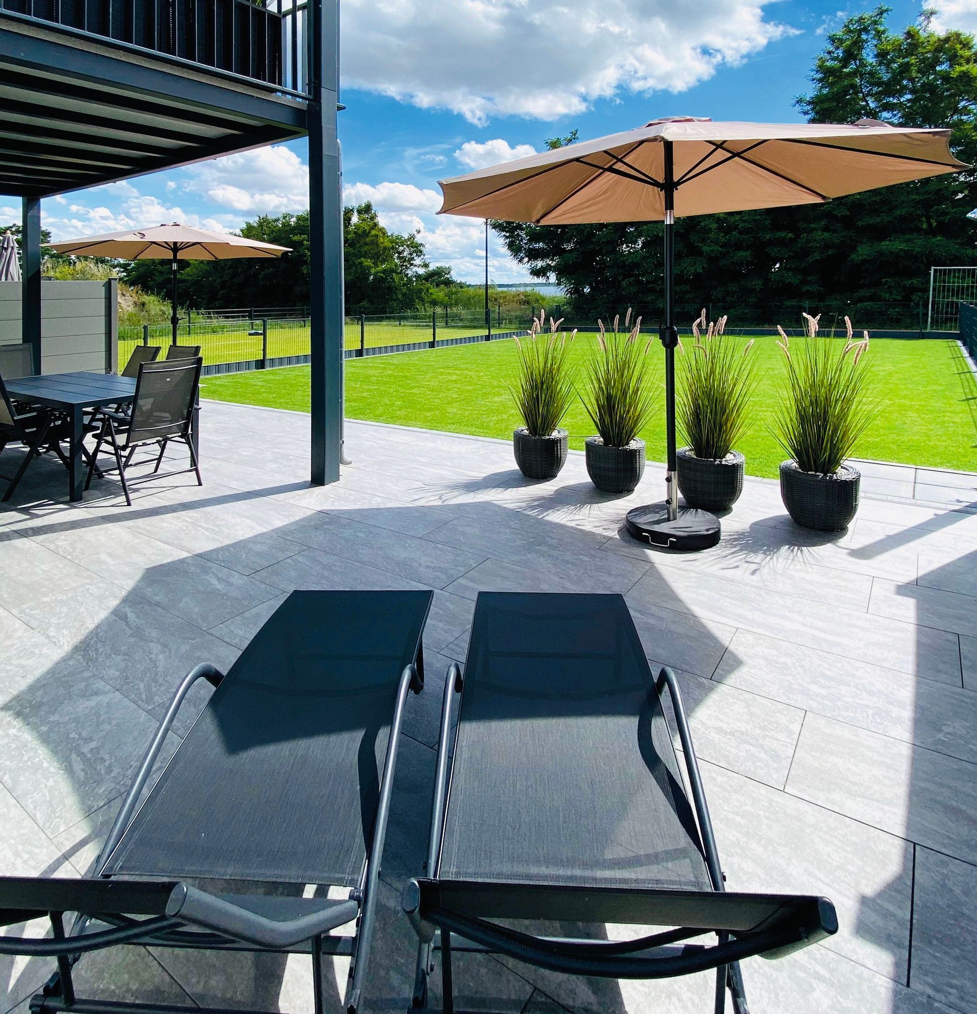 Außenbereich mit riesiger Terrasse und gepflegtem Rasen
