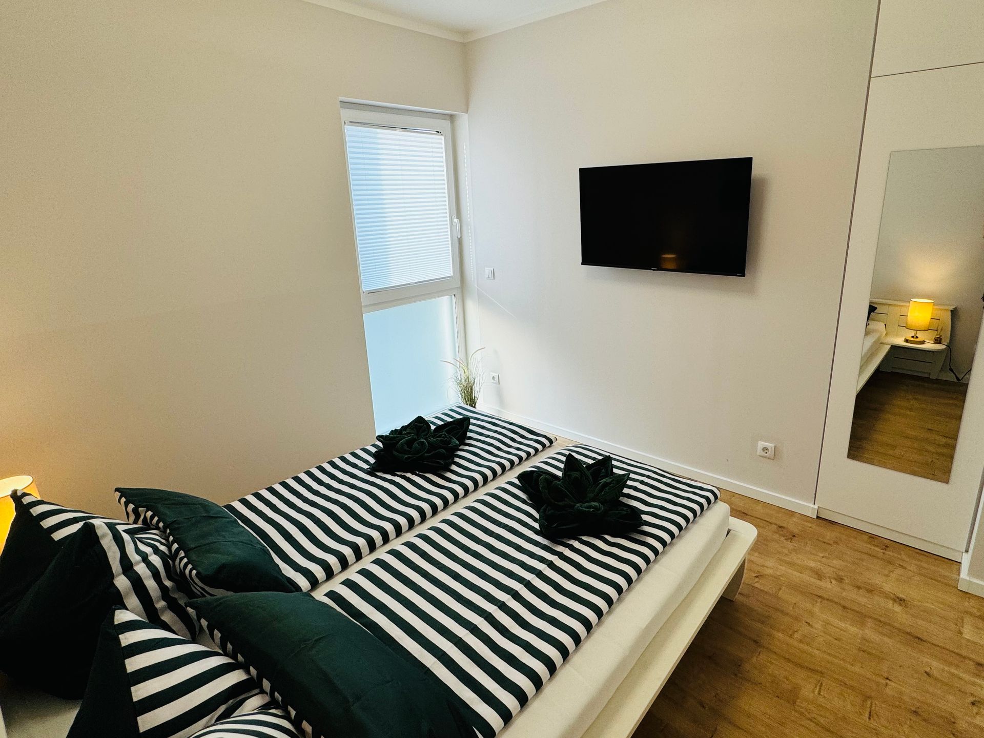 Das kleine Schlafzimmer mit Smart-TV und Deckenventilator