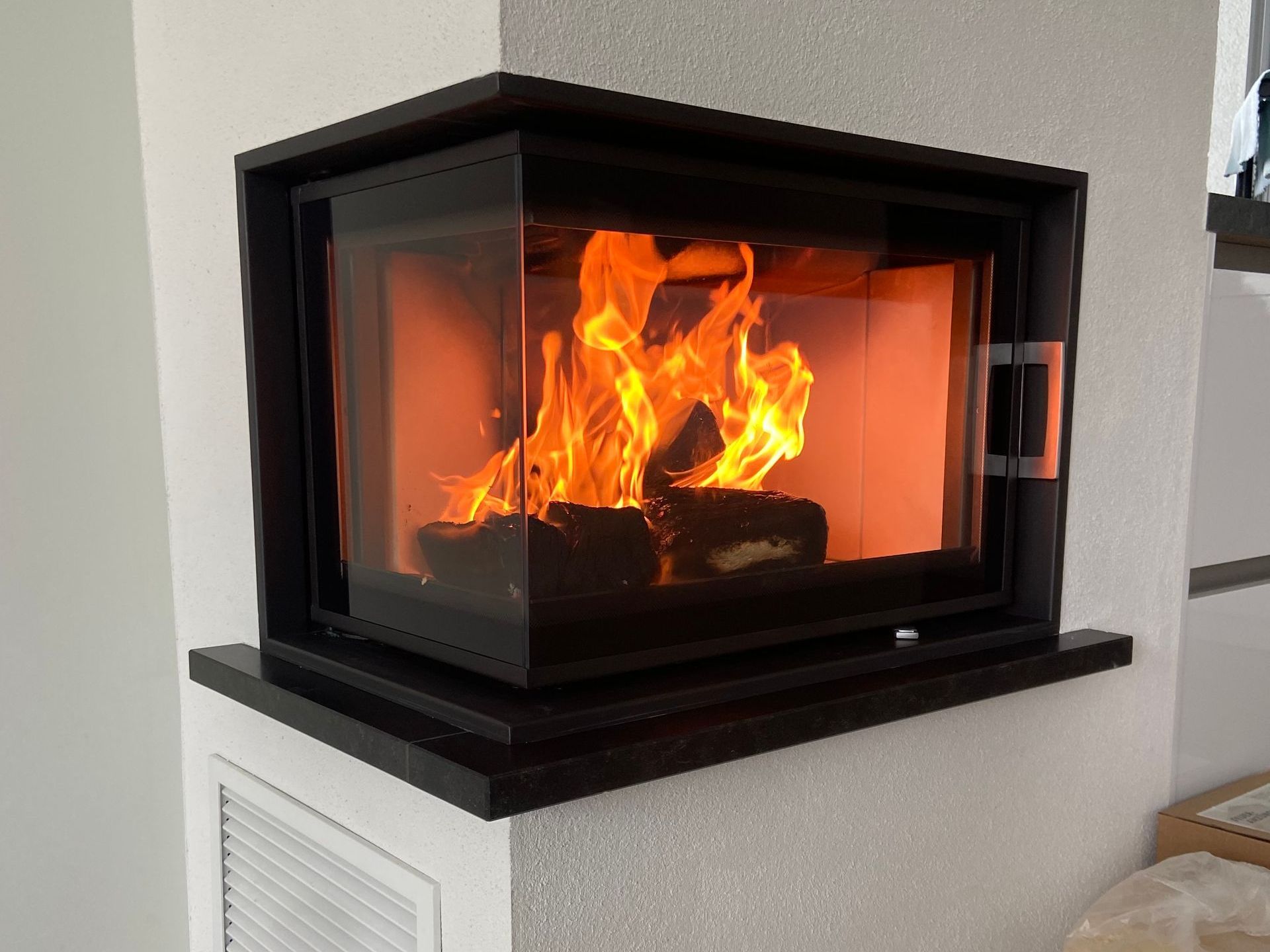 Holzbrand-Kamin mit Eckverglasung