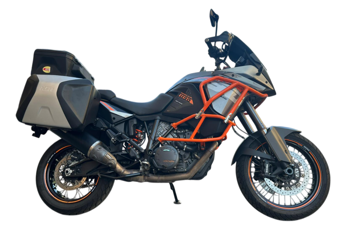 Moto avventura KTM grigia con barre protezione arancioni e borse laterali, vista frontale