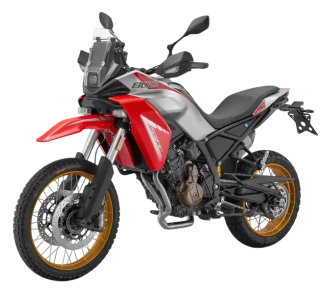 Una motocicletta da avventura Honda Transalp argento e rossa con cerchi a raggi dorati su uno sfondo bianco uniforme.