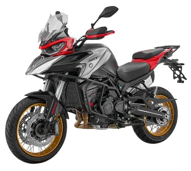 Una motocicletta adventure elegante, color argento e rosso, con cerchi a raggi dorati, barre di protezione laterali