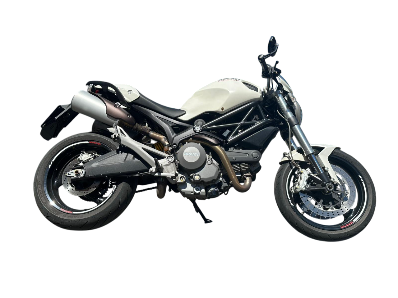 Una motocicletta Ducati Monster bianca, inclinata verso sinistra, isolata su uno sfondo bianco.