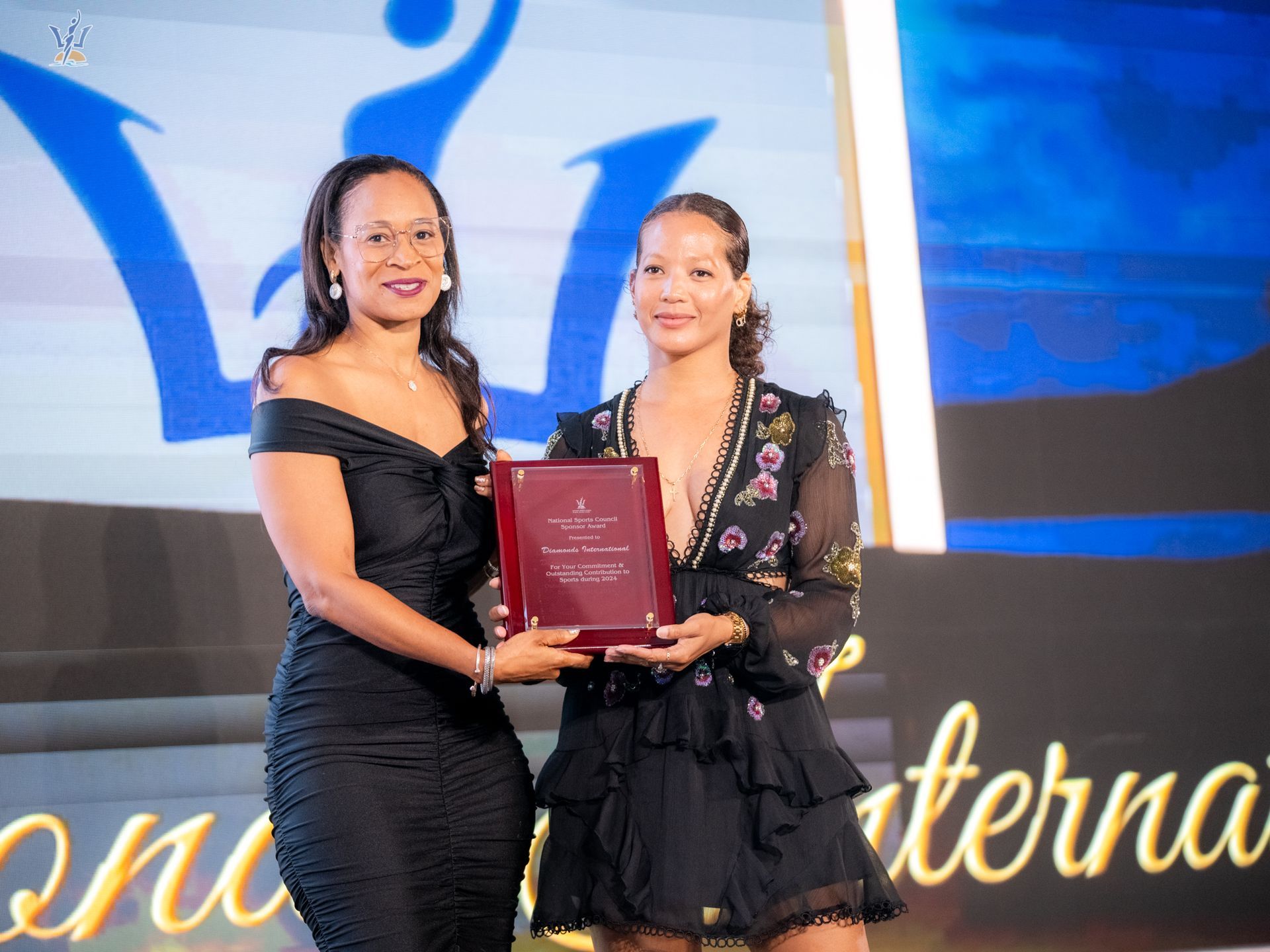 Assistant Marketing Manager of Diamonds International, Caroline Reid accepting the award from Mrs. Rhea Mapp-Bynoe, Chairperson of the National Sports Awards (Photo: TQ Media)