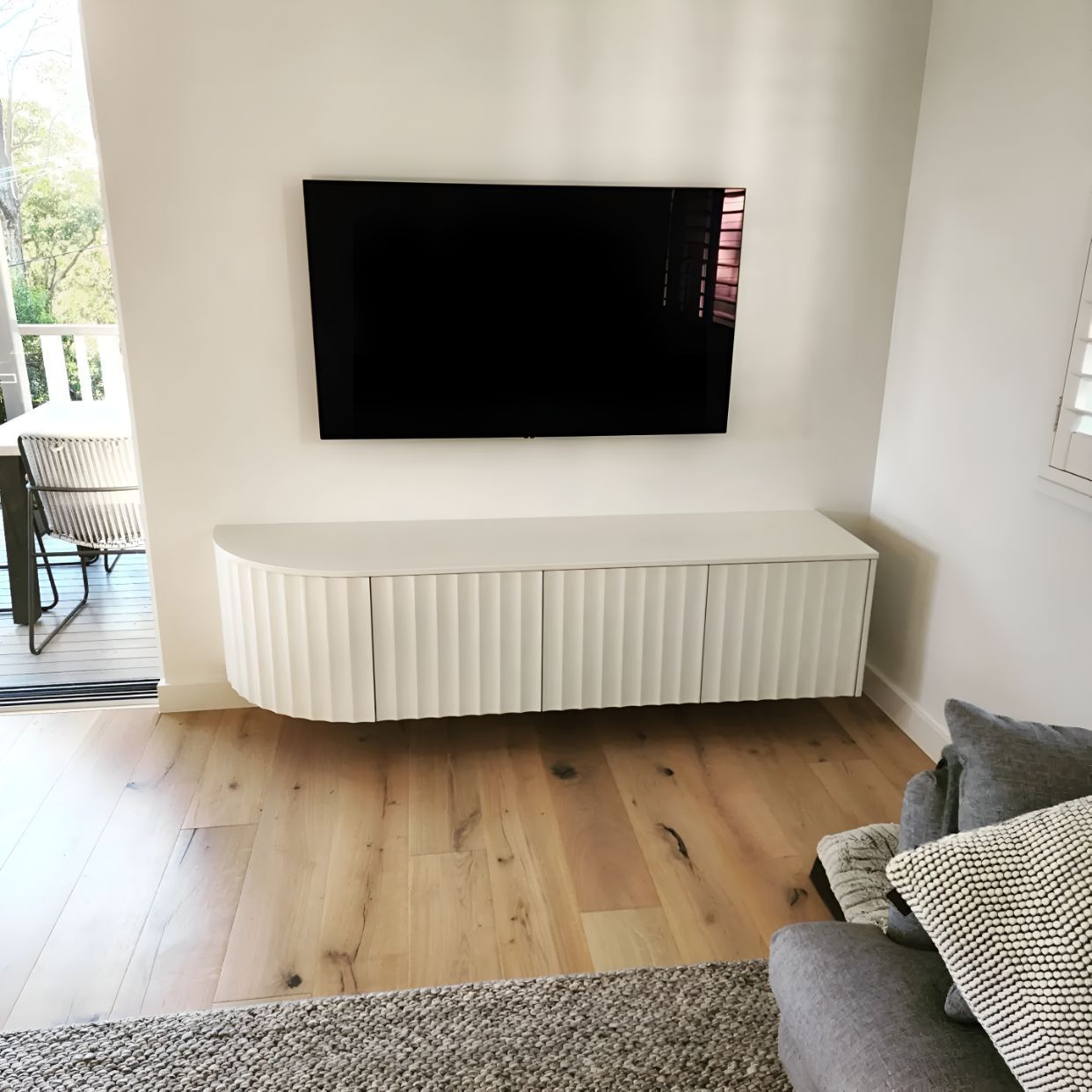 A Living Room With a Flat Screen Tv Mounted to the Wall — Garry Jeans Kitchens In Cardiff, NSW