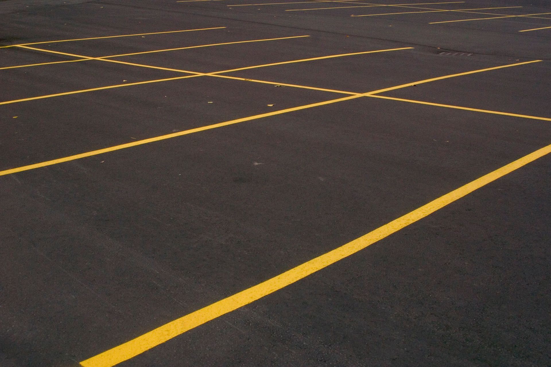 Freshly paved asphalt parking lot in Summit County, CO with bright yellow lines.