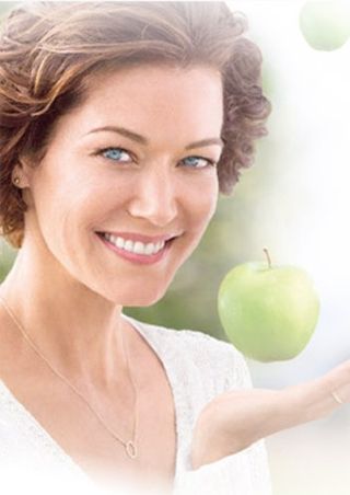 woman with clear skin holding apples