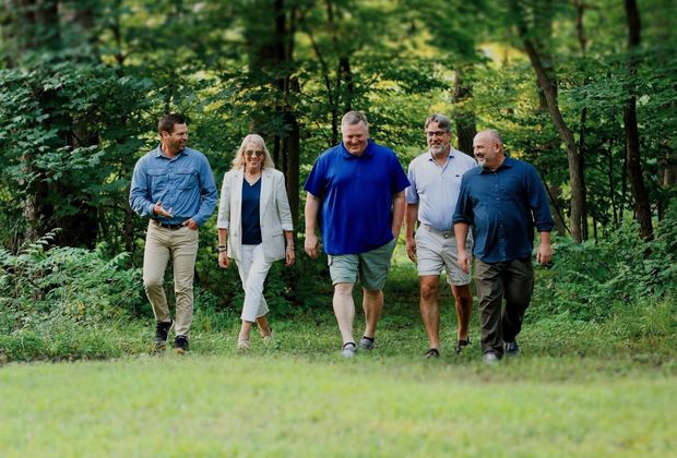 A group of people are walking through the woods.
