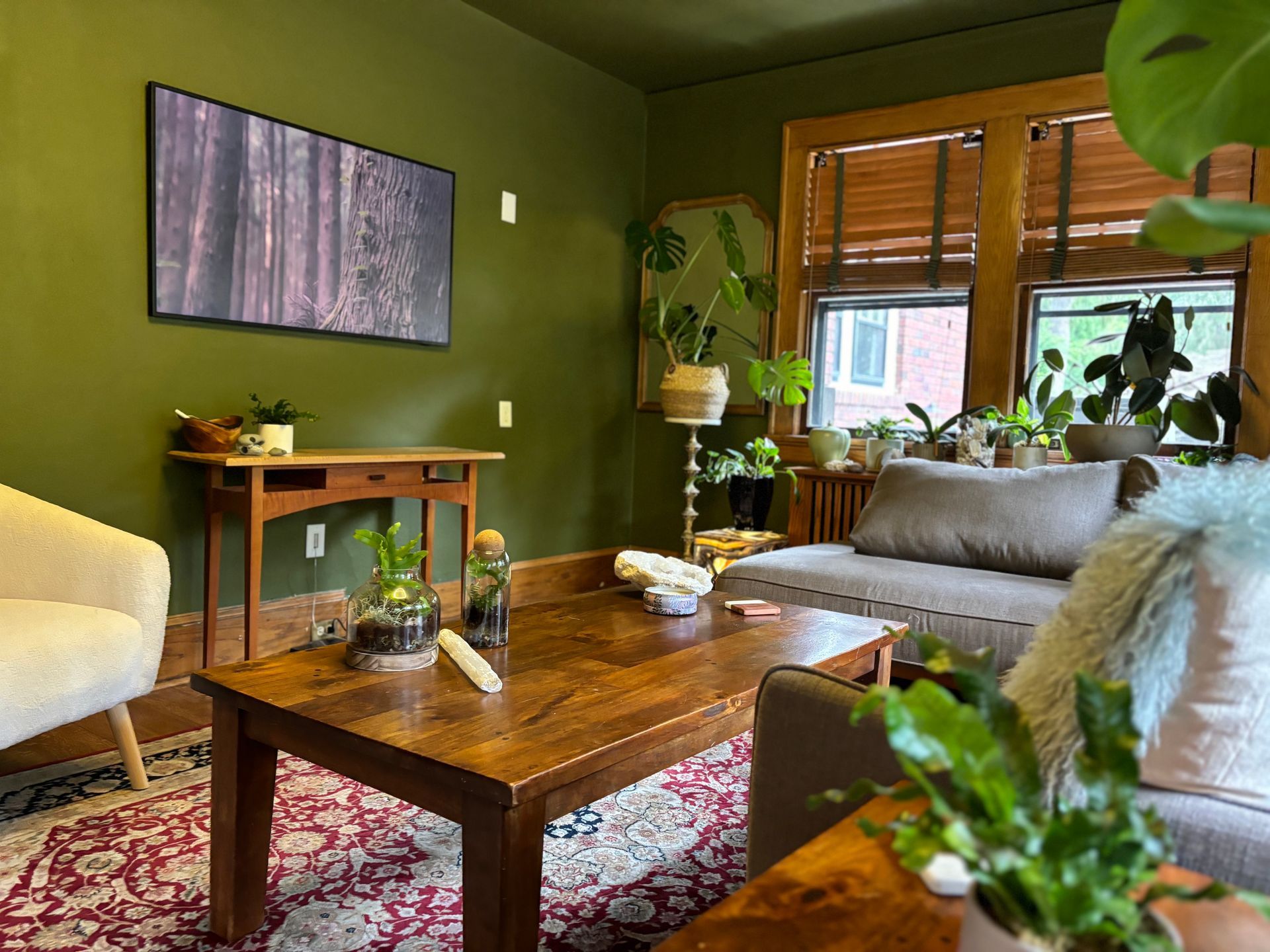 A living room with green walls and a wooden coffee table.