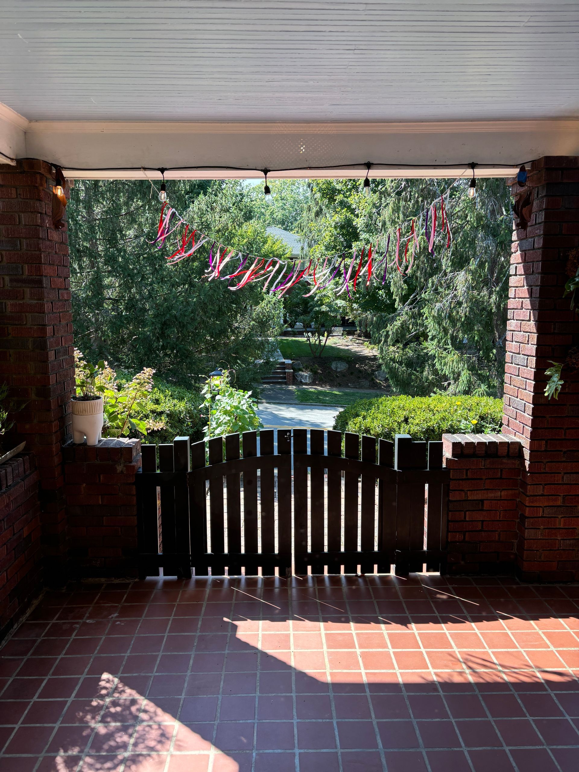 A porch with a wooden gate and a view of trees