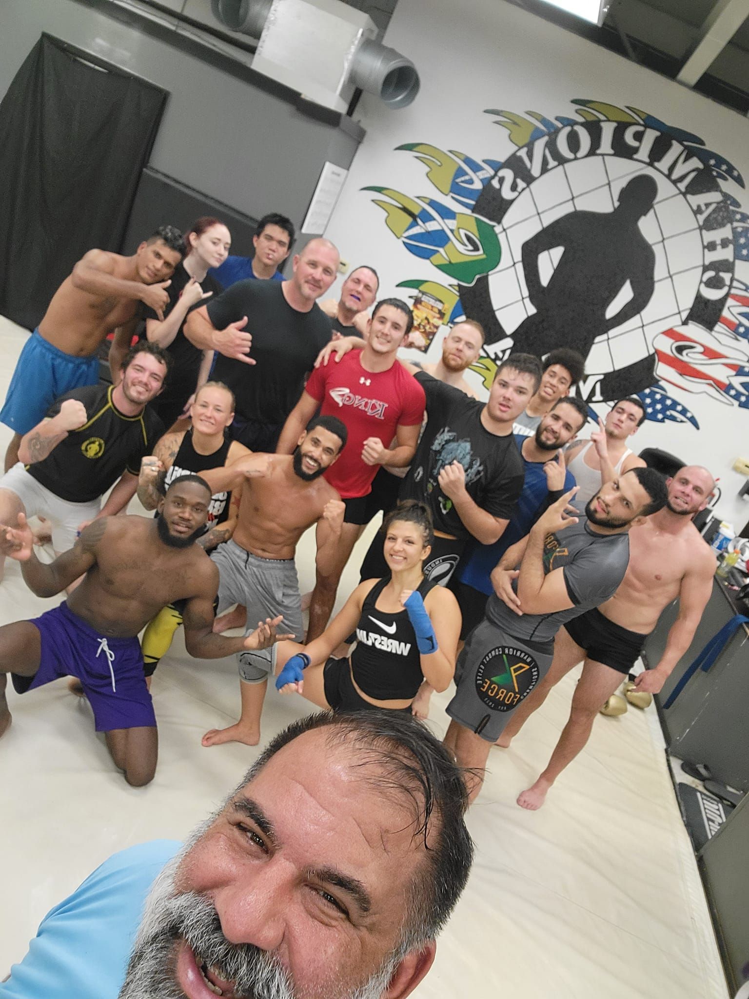A group of people are posing for a picture in a gym.