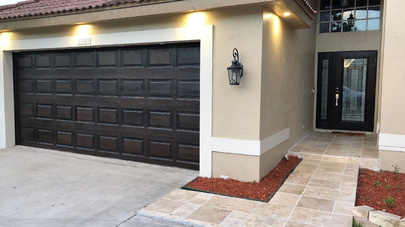 A house with a black garage door and a black door