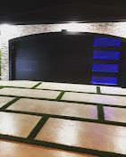 A large black garage door with a blue light behind it.