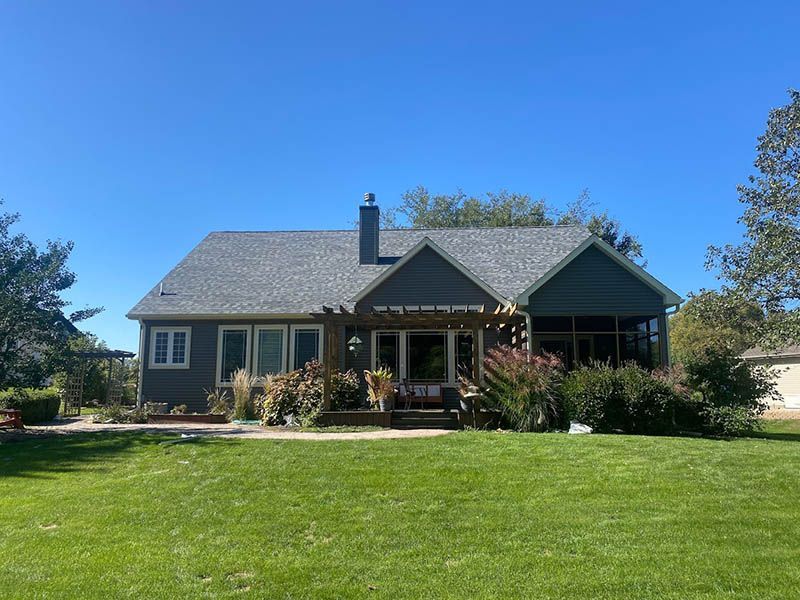 A house with a large lawn in front of it on a sunny day.