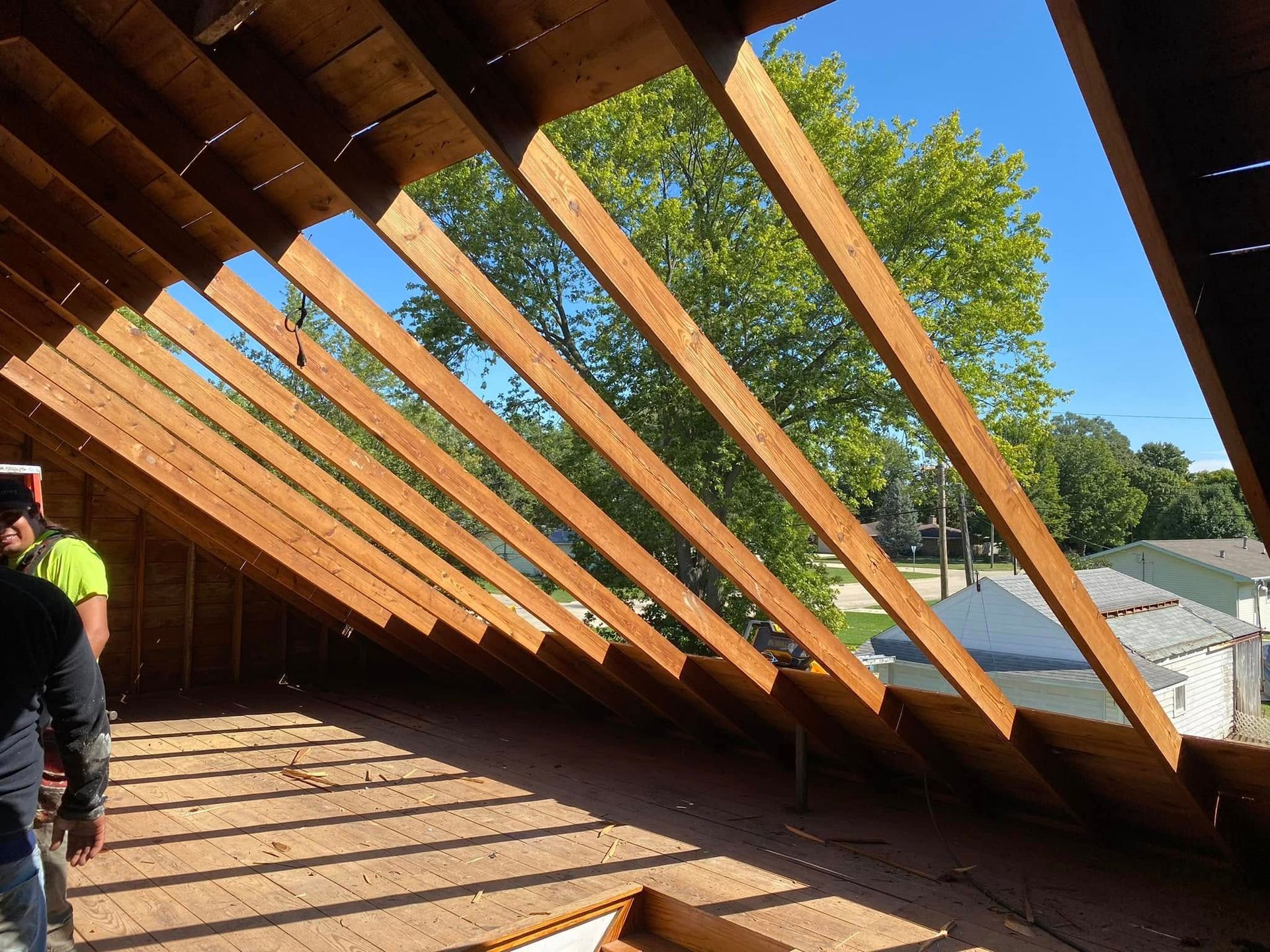 A man is standing in the attic of a house under construction.