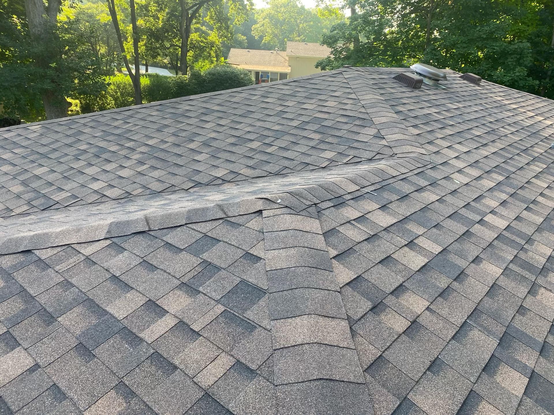 A close up of a roof with a few trees in the background.