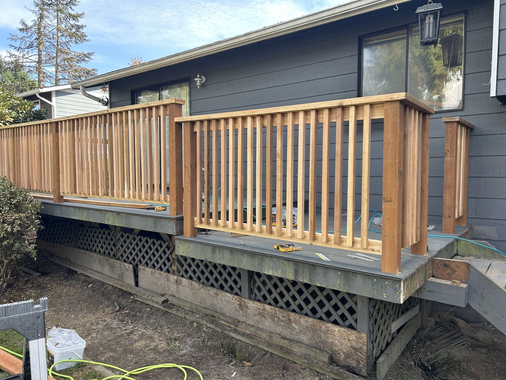 Wooden deck railing and steps beside a dark house exterior
