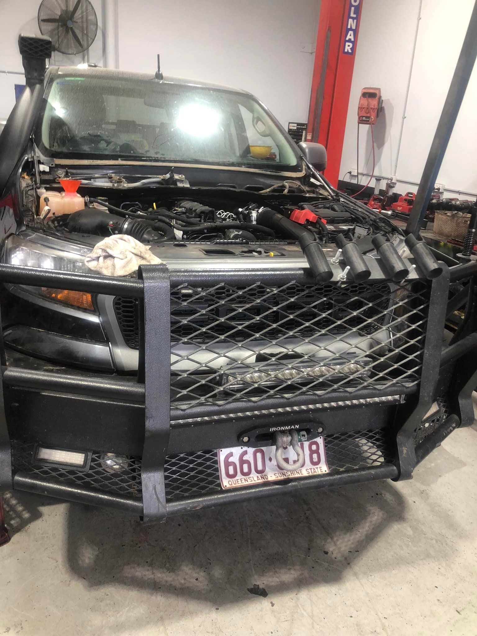 Black Truck With the Hood Open in a Garage — Diesel Engine Rebuilding Australia in Gold Coast, QLD