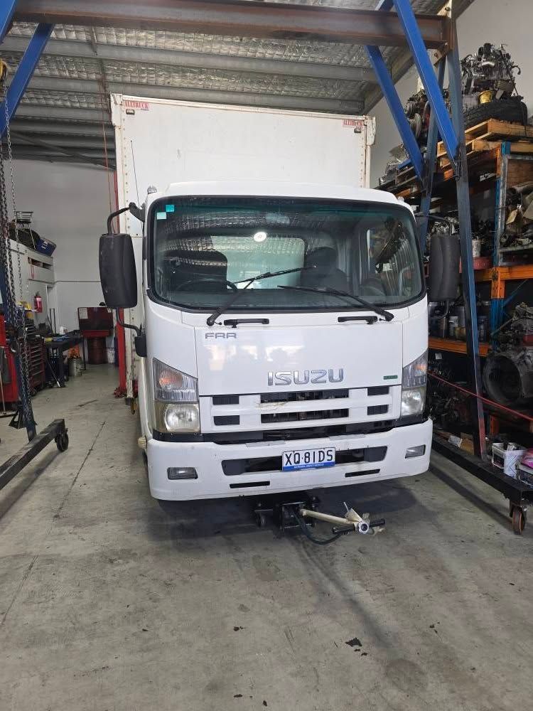 White Isuzu Box Truck in a Garage, Facing Forward — Diesel Engine Rebuilding Australia in Gold Coast, QLD
