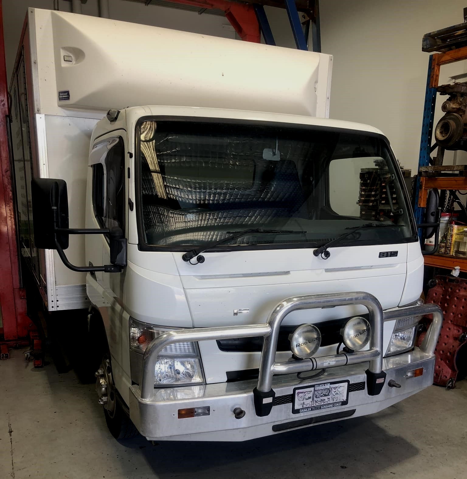 White truck with a cargo box in a workshop. Silver bull bar.  — Experienced Mechanics on the Gold Coast, QLD