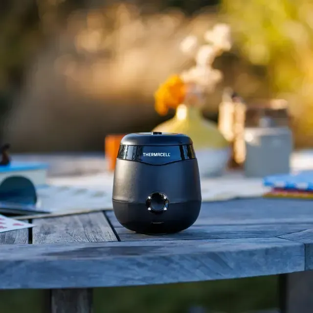 Thermacell mosquito deterrent device sitting on a outdoor table. 