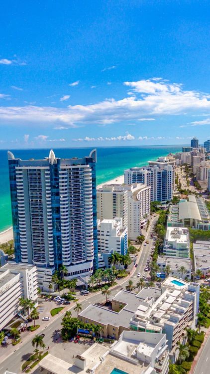An aerial view of a city with lots of buildings and a beach.