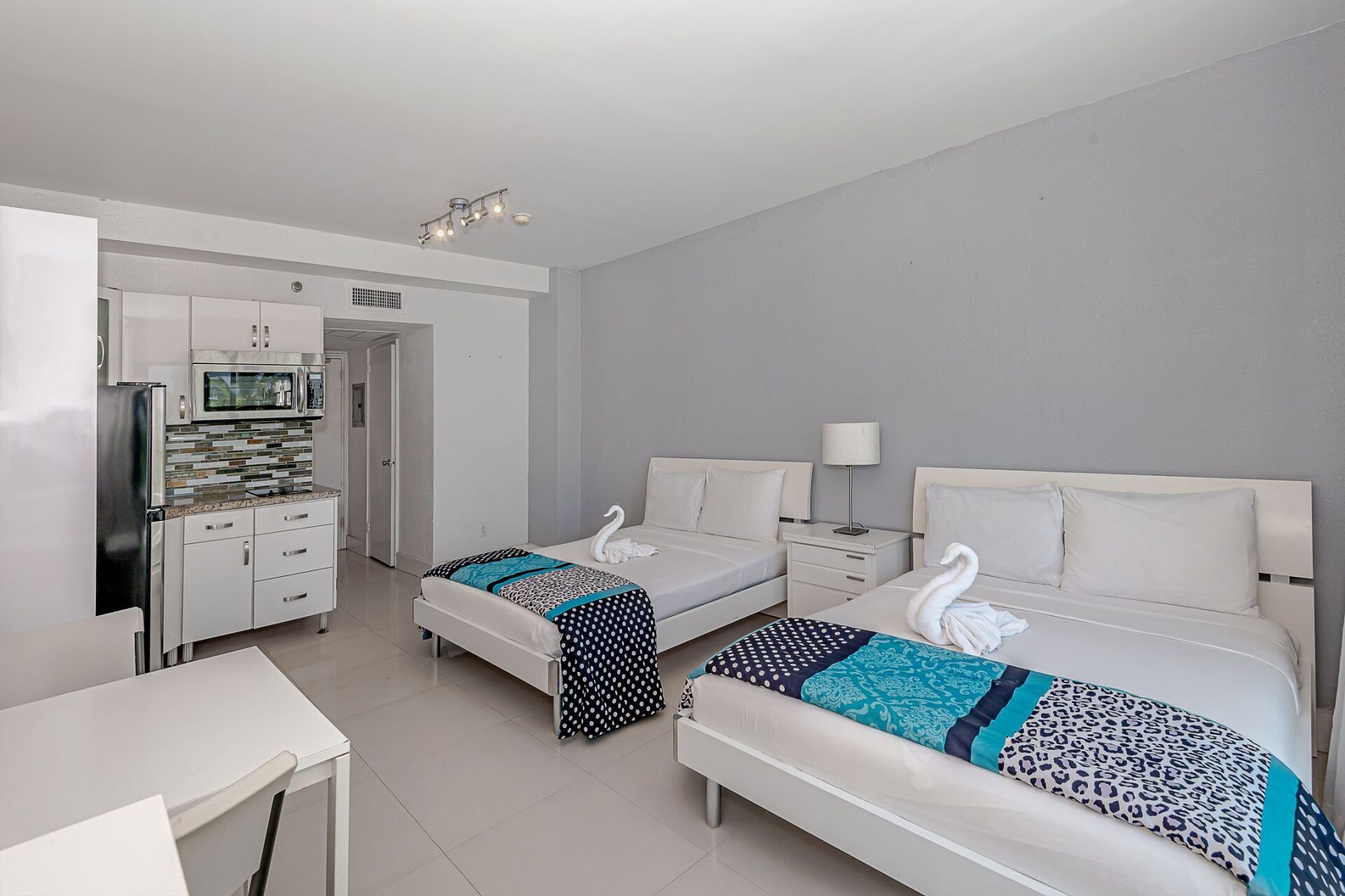 A hotel room with two beds and a kitchen.