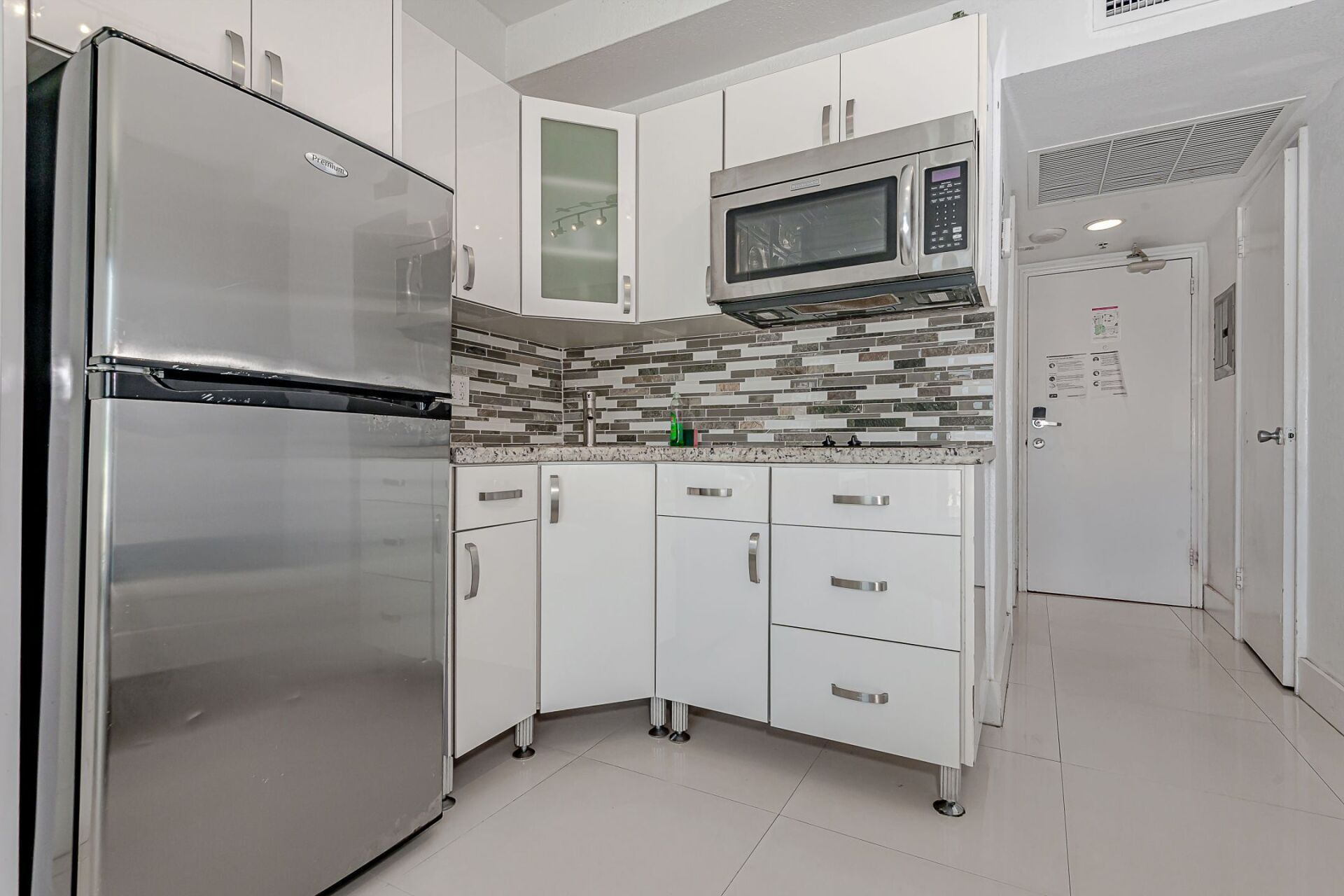 A kitchen with stainless steel appliances and white cabinets.