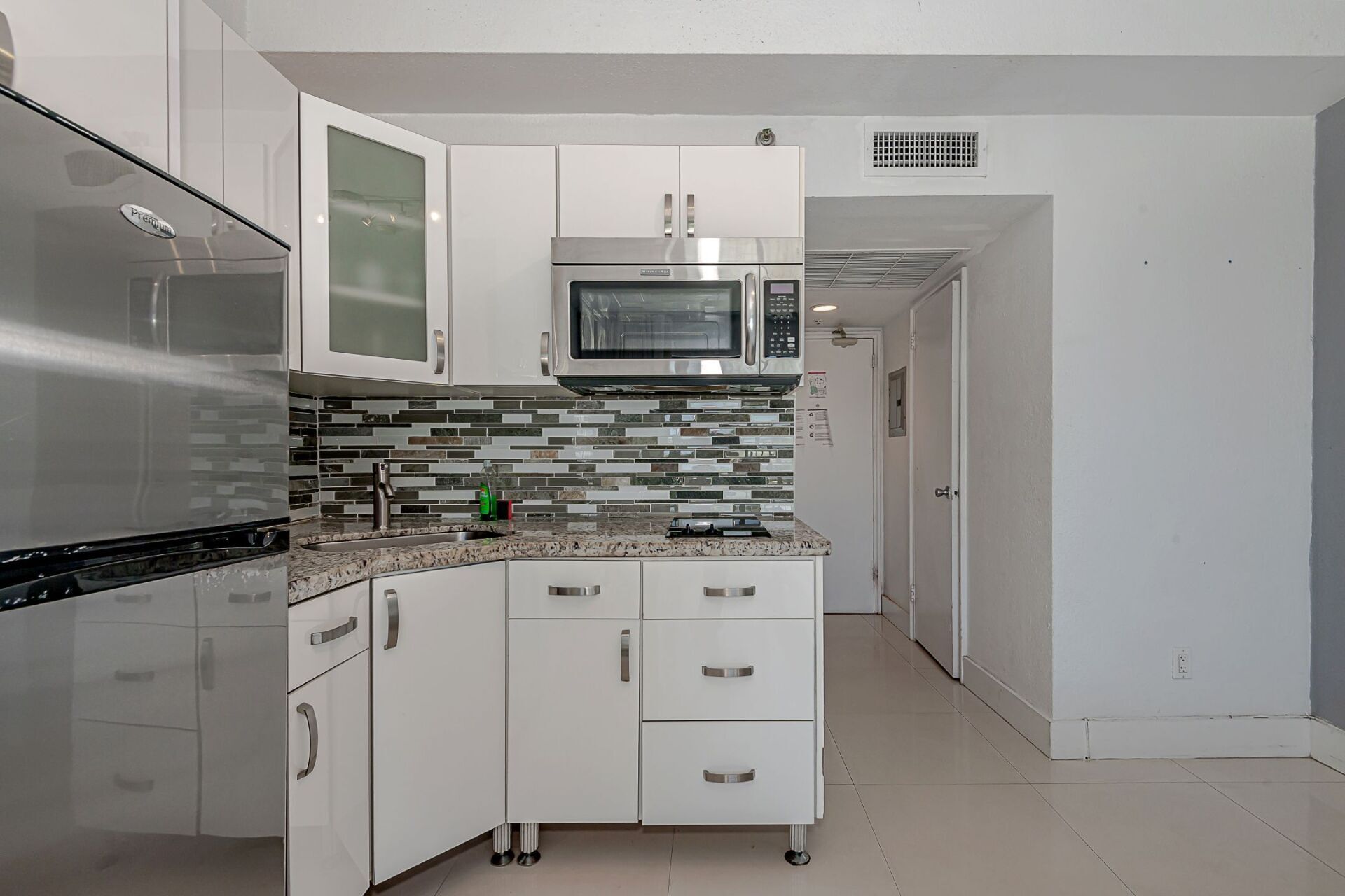 A kitchen with white cabinets and stainless steel appliances