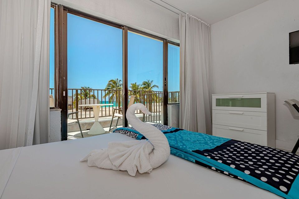 A hotel room with a swan made out of towels on the bed.