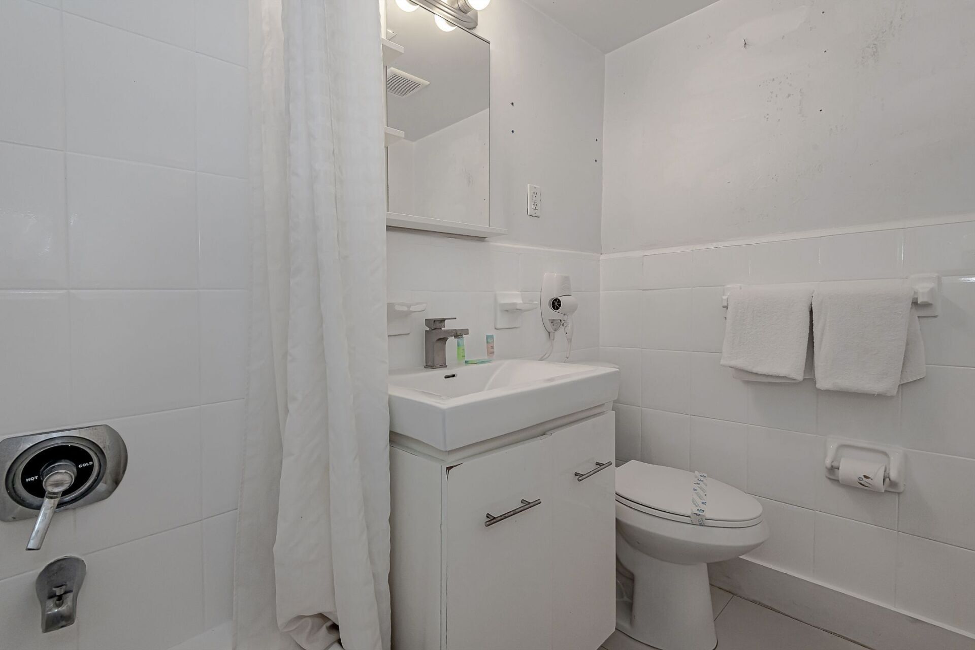 A bathroom with a sink , toilet , shower and bathtub.