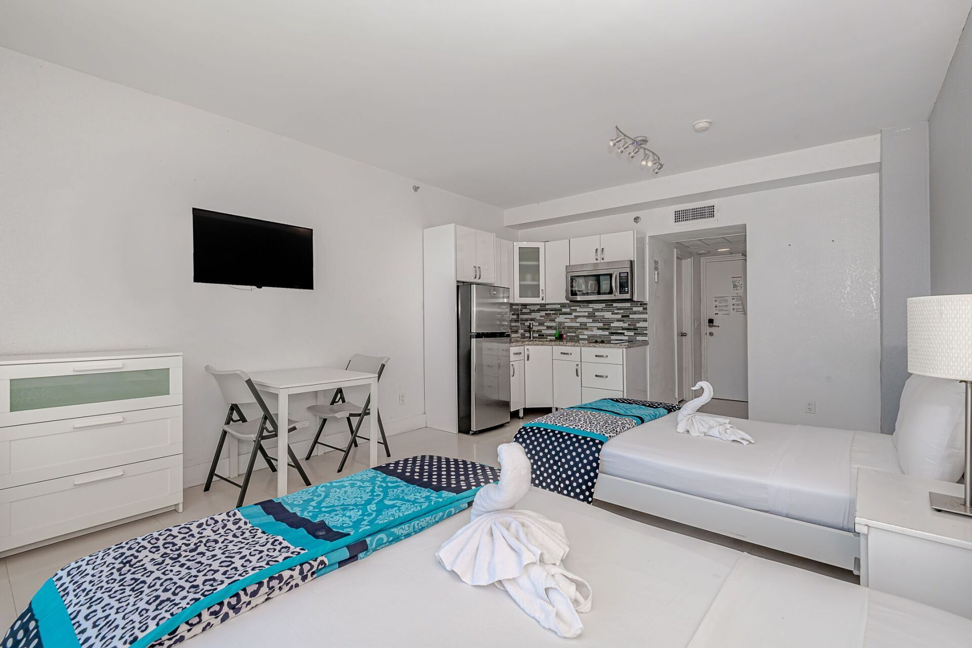 A hotel room with two beds , a table and a television.