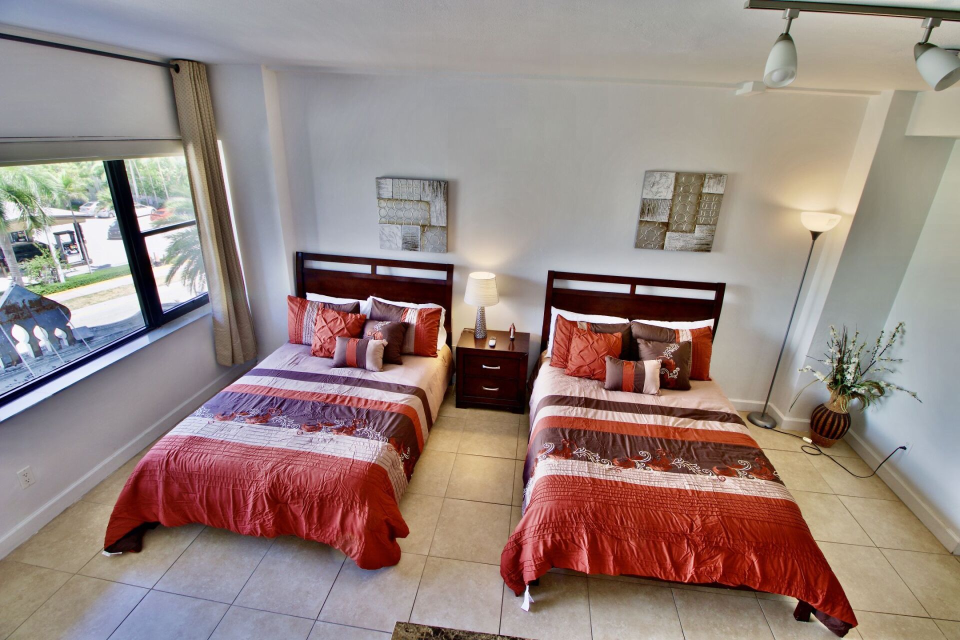 A bedroom with two beds and a window