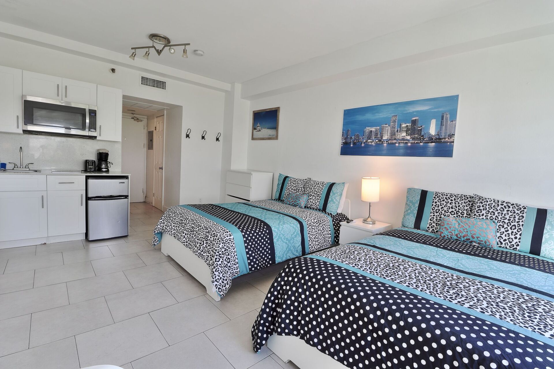 A hotel room with two beds and a kitchen