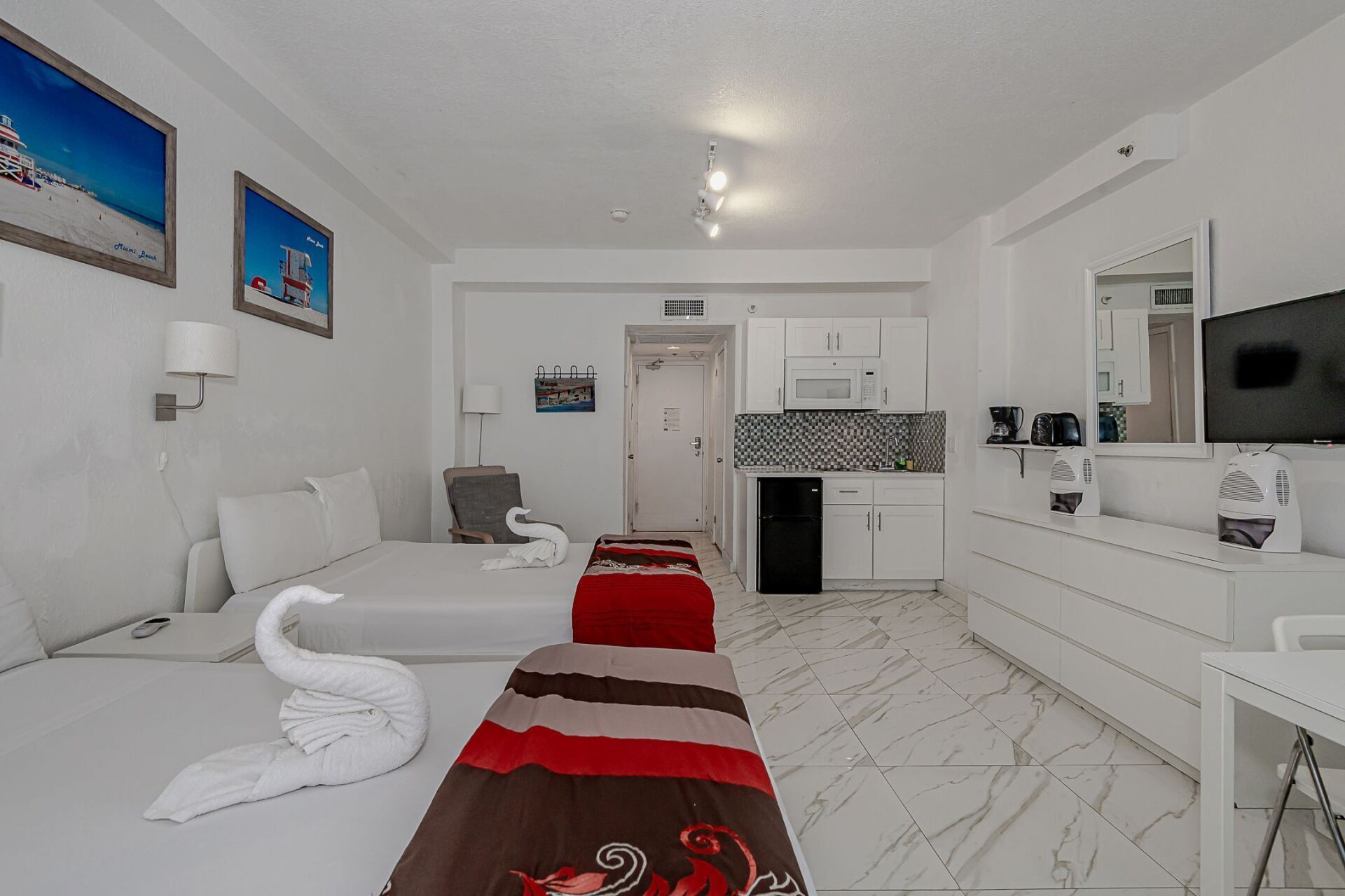 A hotel room with two beds and a kitchen