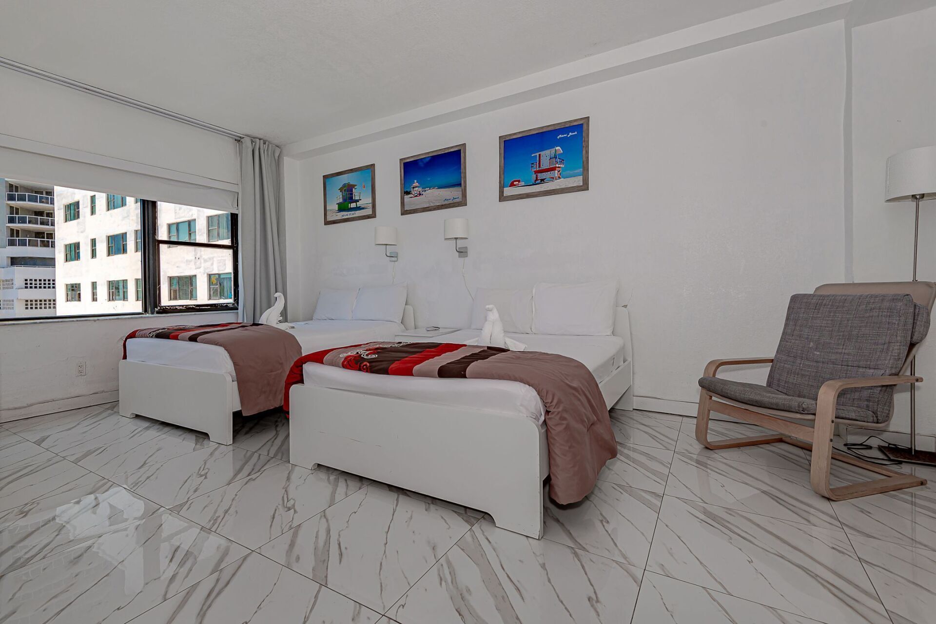 A hotel room with two beds and a chair.