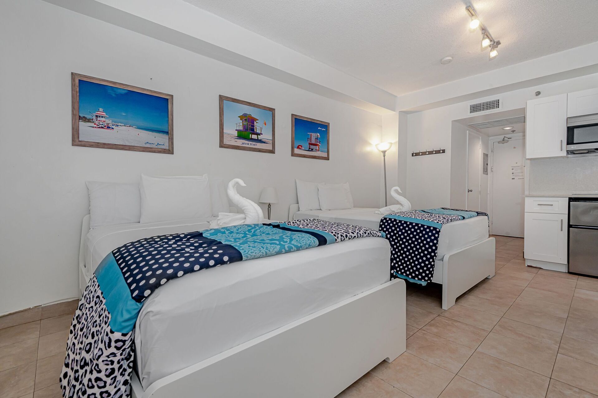 A hotel room with two beds and a kitchen.