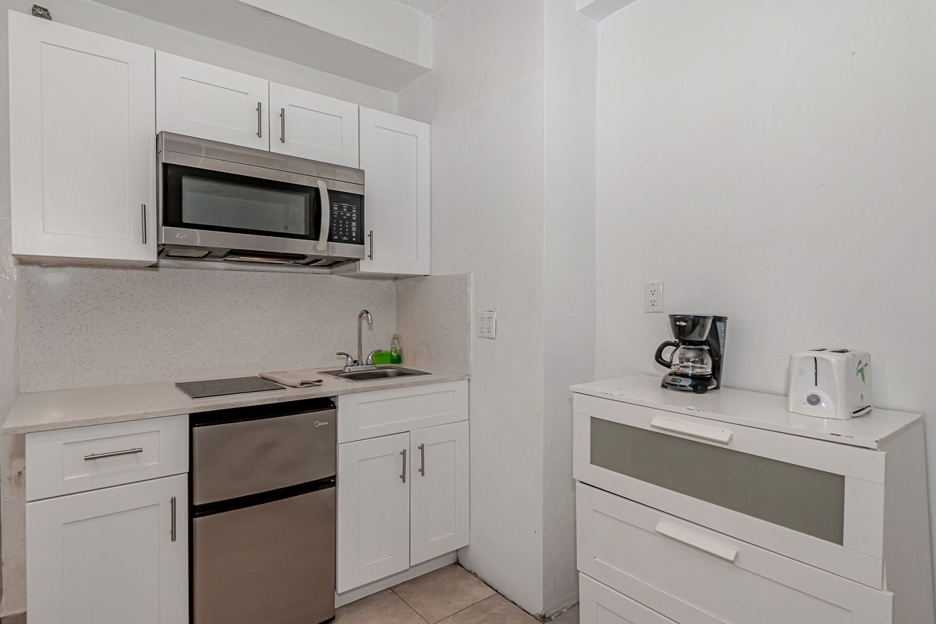 A small kitchen with stainless steel appliances and white cabinets.