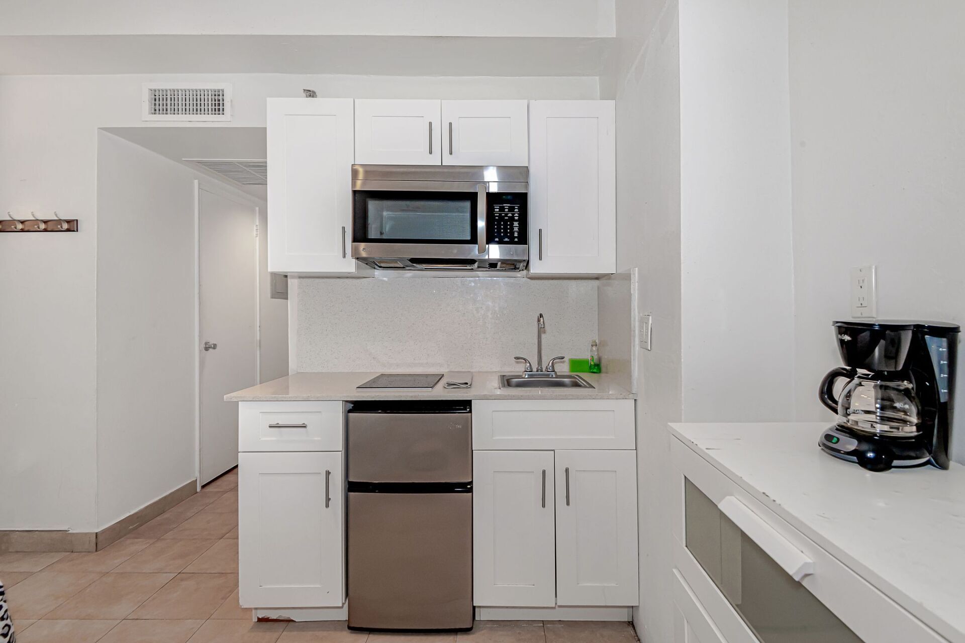 A small kitchen with stainless steel appliances and white cabinets