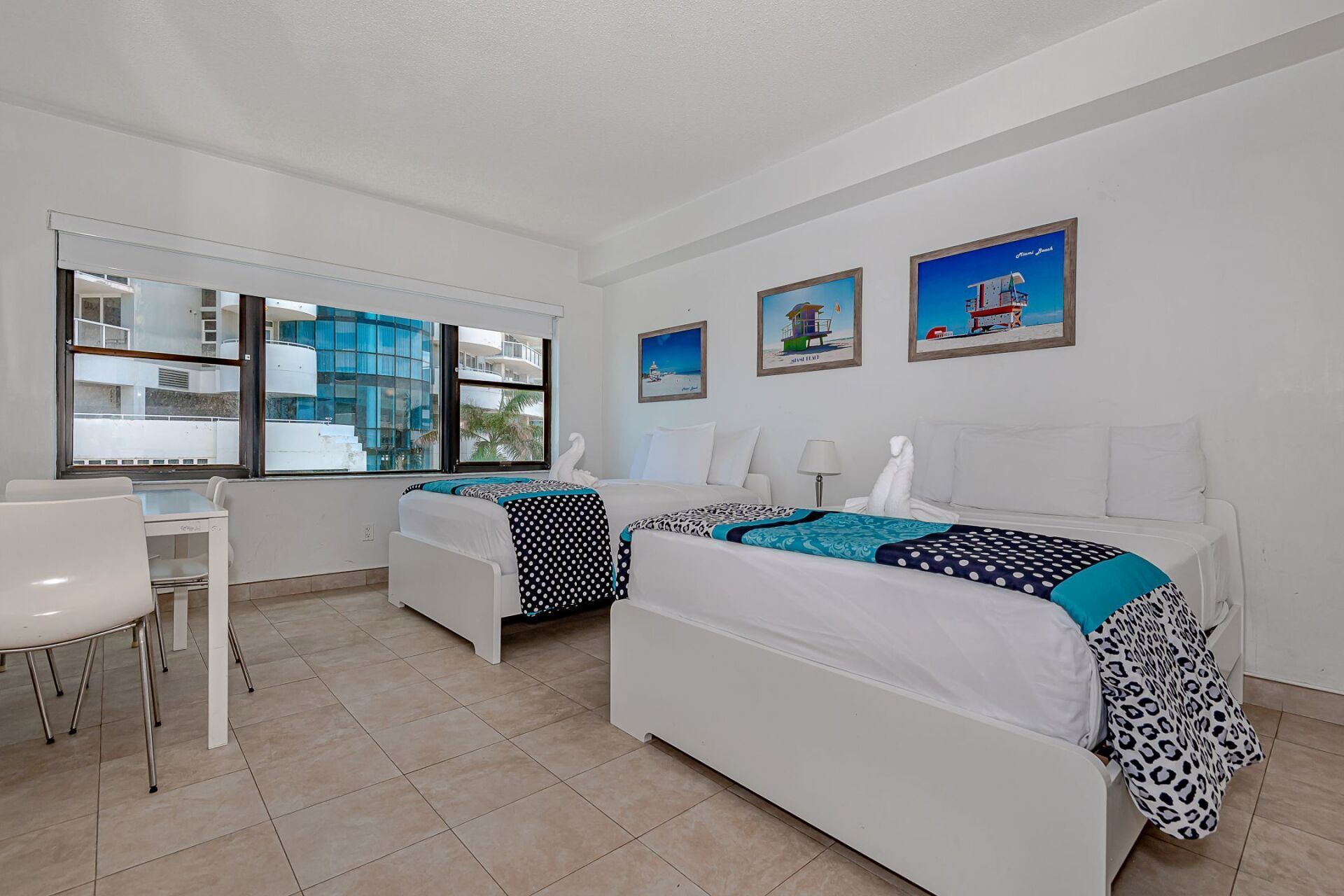 A hotel room with two beds and a desk.