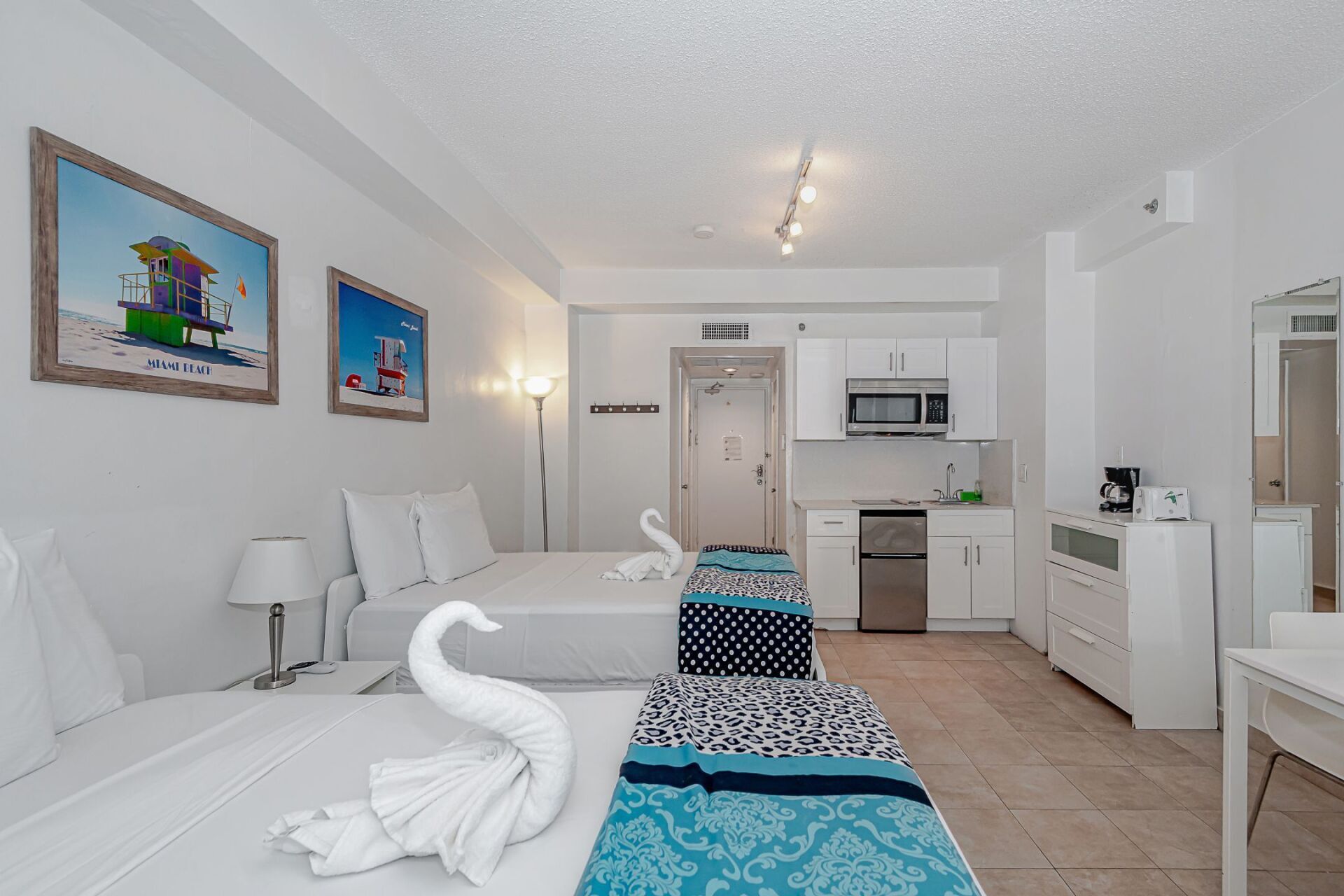 A hotel room with two beds and a kitchen