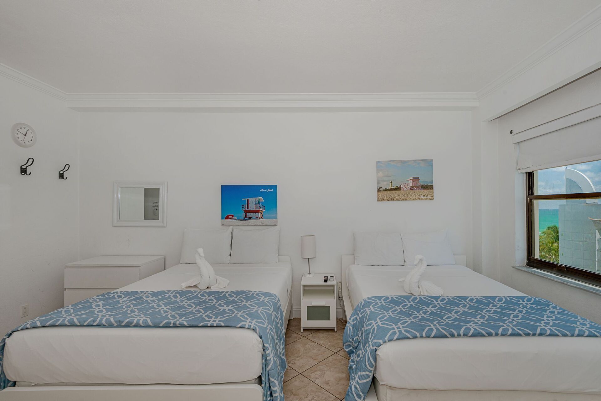 A bedroom with two beds and a window.