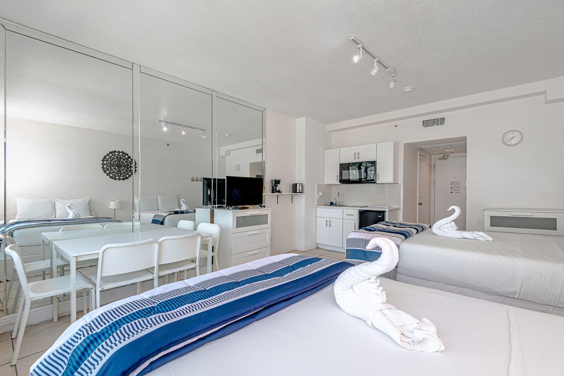 A hotel room with a bed , dining table and chairs.