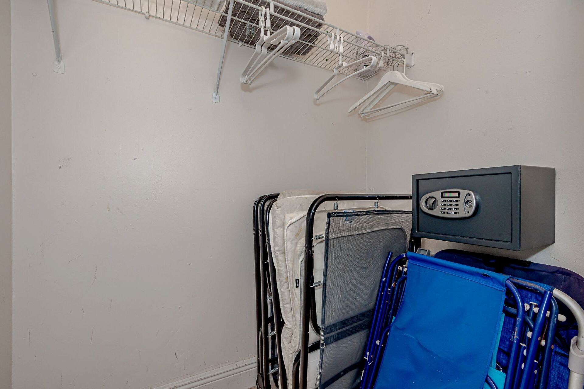 A closet with a bed and a safe in it.