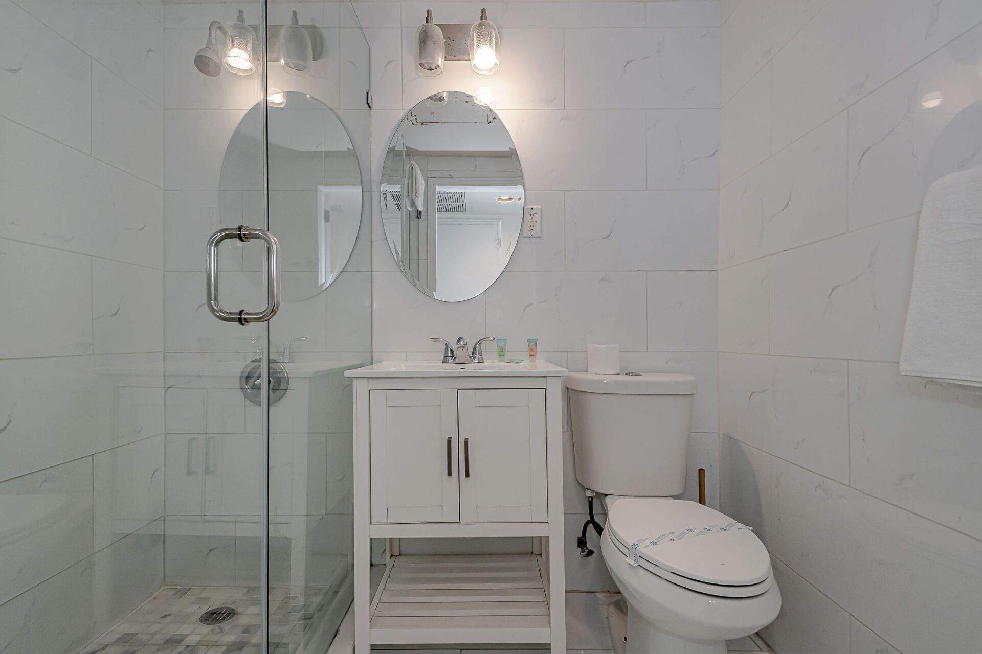 A bathroom with a toilet , sink , and shower.